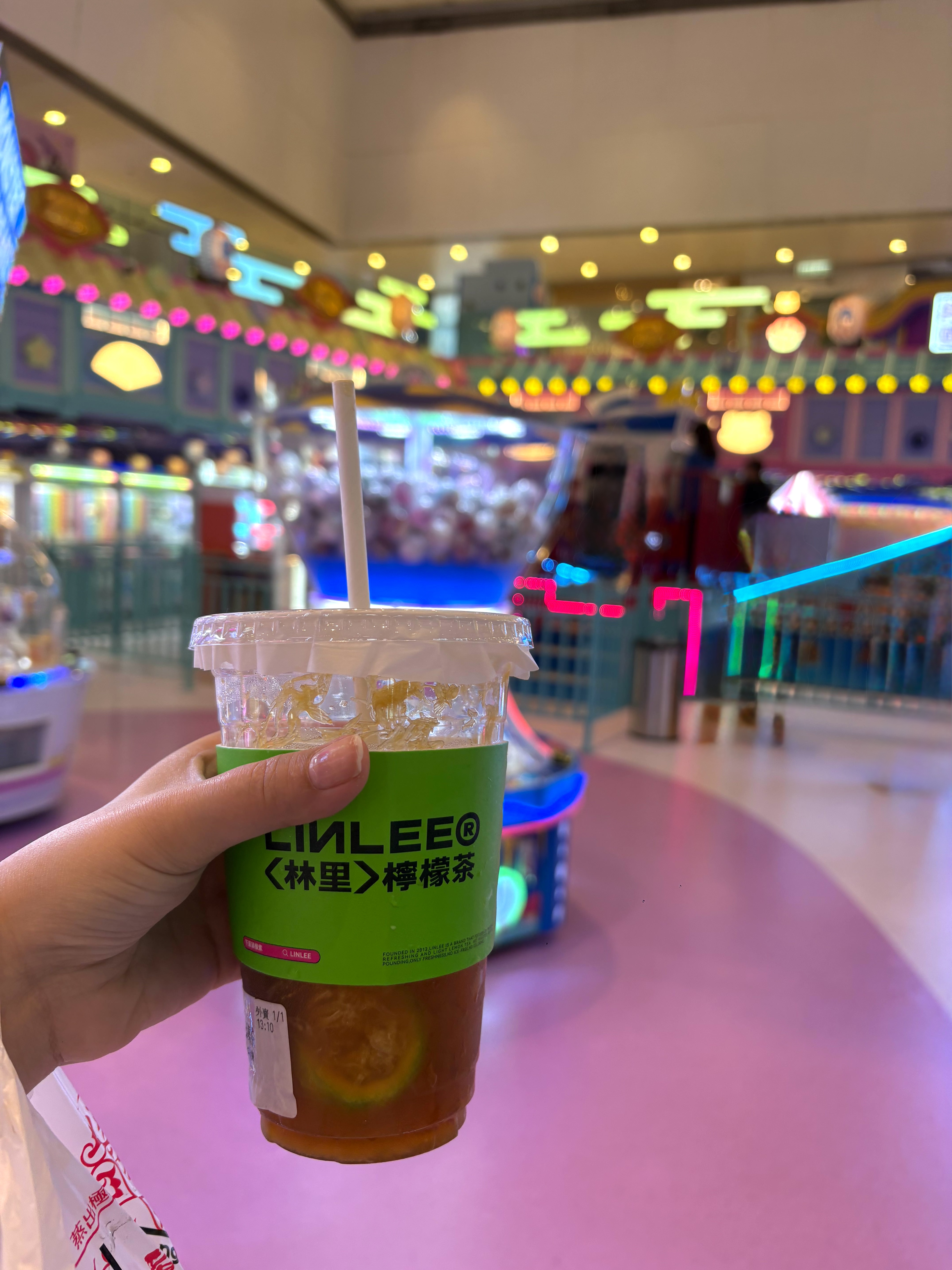 Cup of Hong Kong-style lemon iced tea held in an arcade