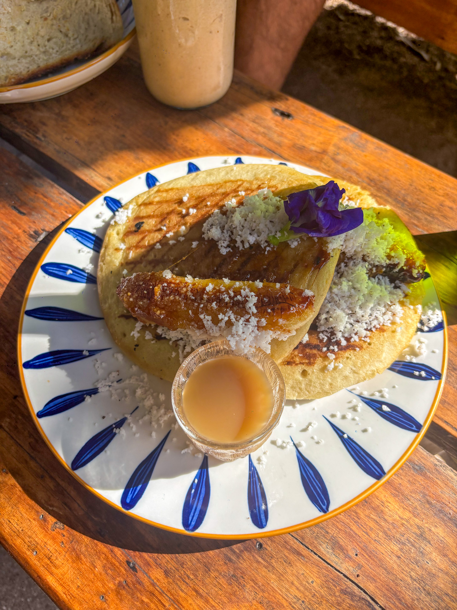 Latik sourdough pancakes with banana and coconut on a patterned plate